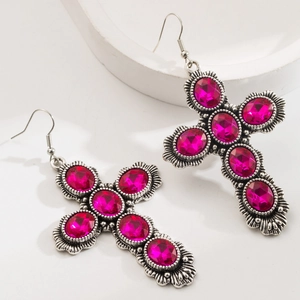 Macro di orecchini a croce in argento con strass rosa su sfondo bianco naturale