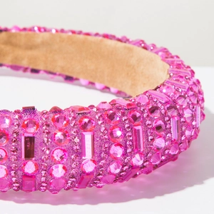Vue détaillée du serre-tête rembourré rose fuchsia orné de strass brillants de luxe