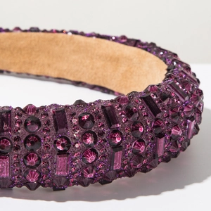 Détail macro du serre-tête en cristal violet avec strass brillants et doublure en daim