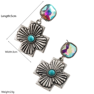 Détail des boucles d'oreilles croix style western avec turquoise et cristal coloré