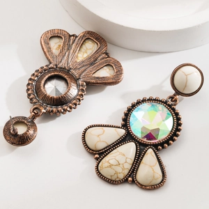 Macro detail of vintage turquoise drop earrings with hollow metalwork and crystal inlay