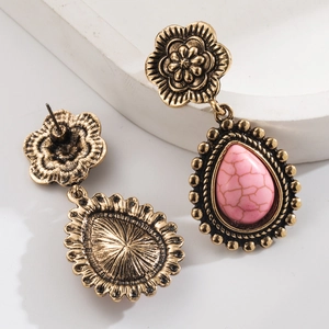 Vue macro de boucles d'oreilles vintage en or avec fleurs, turquoise rose et détails au dos