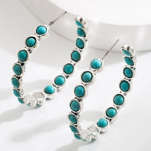 Bohemian silver hoop earrings featuring turquoise bead inlay from a 45-degree angle view