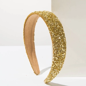 Serre-tête large élégant avec paillettes dorées et perles sur fond géométrique blanc