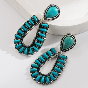 Detail of silver-finish bohemian earrings with turquoise stones and twisted rope textures