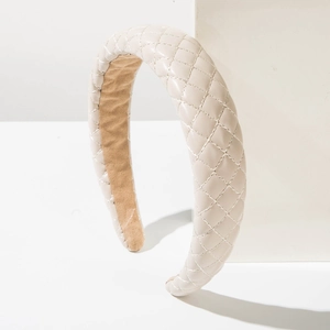 Detail of cream leather headband with quilted diamond stitching on a white block