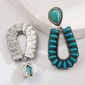 Detail of bohemian turquoise earrings with vintage silver metal and intricate rope patterns