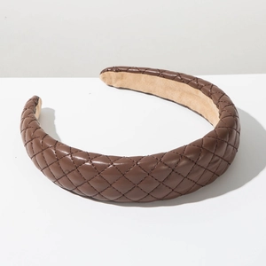 Detailed close-up of dark brown quilted faux leather padded headband with diamond stitching