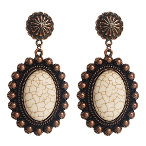 Vista dettagliata di orecchini boho in bronzo con pietre ovali bianche e motivi floreali