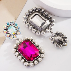 Détail macro de boucles d'oreilles bohèmes avec cristaux roses et bordures en perles