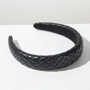 Macro view of black quilted faux leather wide headband with thick padded design