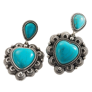 Macro detail of western boho turquoise heart earrings with intricate silver metal texture