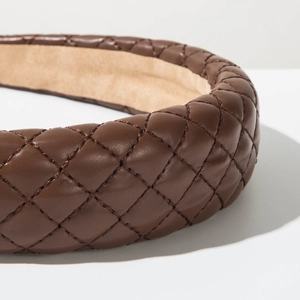 Close-up of brown quilted leather headband with detailed diamond stitching and soft lining