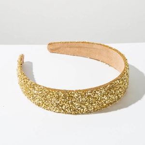 Détail d'un serre-tête large doré orné de cristaux brillants et d'une bordure perlée