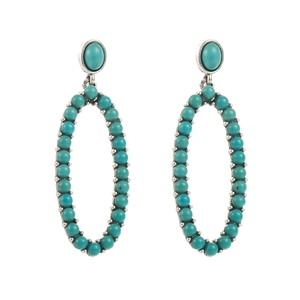 Detailed macro view of bohemian oval turquoise bead earrings with vintage silver alloy frame