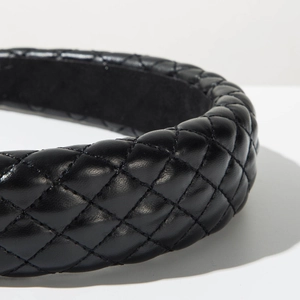 Close-up of black quilted faux leather headband with luxury padded texture details