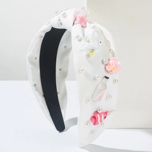 Détail du serre-tête blanc avec nœud, perles fantaisie, étoiles de mer et coquillages