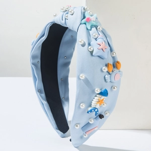 Détail d'un serre-tête bleu clair thème marin avec perles, étoiles de mer et crabe