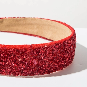 Détail du serre-tête rouge avec paillettes étincelantes et doublure en daim antidérapante