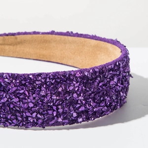 Détail du serre-tête violet pailleté avec cristaux scintillants et doublure marron doux