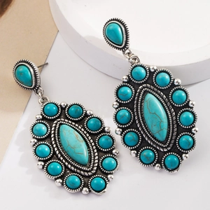 Macro detail of Bohemian vintage earrings featuring turquoise stones and silver-tone metal