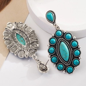 Close-up of Bohemian silver earrings with teardrop turquoise stones and vintage textures