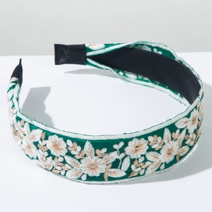 Close-up of bohemian green fabric headband with intricate floral embroidery