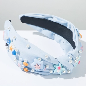 Détail d'un serre-tête bleu clair avec motifs marins et perles blanches décoratives