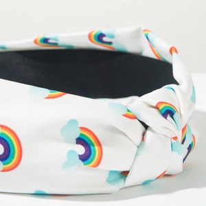 Detail van een witte geknoopte hoofdband met regenboog- en wolkenpatronen voor kapsels