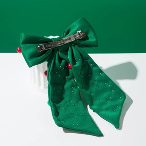 Detail einer grünen Satin-Weihnachtsschleife mit silberner Metall-Haarspange