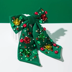 Festliche grüne Haarschleife für Weihnachten mit bunten Sternen und Perlen für Feiern