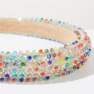 Makroaufnahme von buntem Perlenstirnband mit glitzernden Strasssteinen und weichem Futter