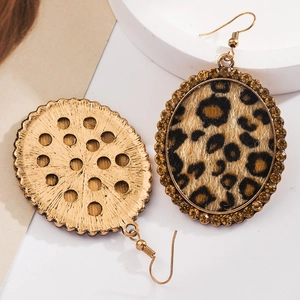 Macro detail of leopard print oval drop earrings with amber rhinestones and gold hooks