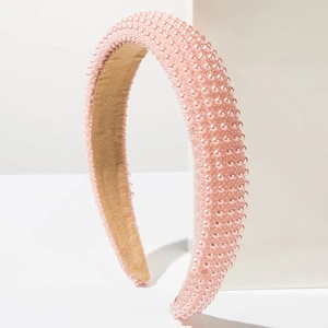 Close-up of pink pearl padded headband with soft velvet lining on white background