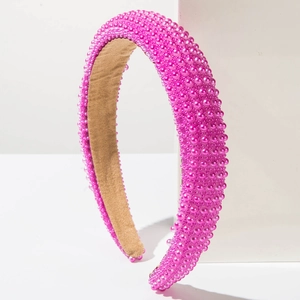 Detail showing hot pink pearls on a wide sponge headband over a velvet inner lining
