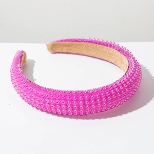 Detailed close-up of a wide padded headband featuring dense rose pink faux pearls