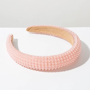 Close-up of pink padded headband with neat pearl embellishments and suede lining