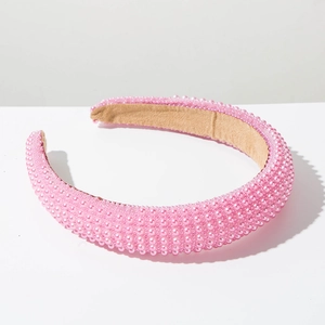 Detailed view of a pink padded headband featuring dense faux pearl embellishments