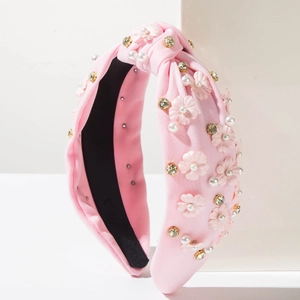 Pink knotted wide headband with 3D fabric flowers, pearls and rhinestones on beige stand