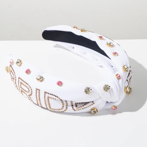 Detailed view of white bridal headband with hand-beaded BRIDE text and sparkling crystals