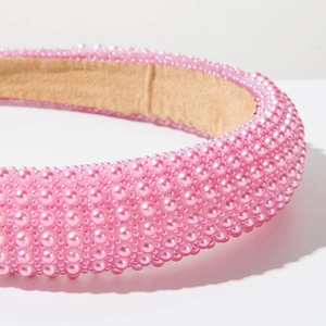 Detail of pink faux pearls on padded headband with soft brown velvet lining inside
