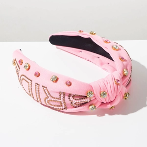 Detail view of pink knotted headband with sparkling rhinestones and Barbie lettering