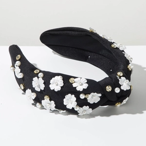 Detailed close-up of knot headband with fabric flowers, faux pearls, and rhinestones