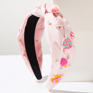 Cerchietto rosa in tessuto intrecciato con perle bianche e decorazioni a forma di caramella