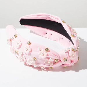 Close-up of pink fabric knot headband with 3D flowers, pearls and rhinestones
