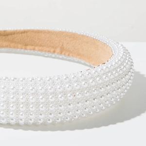 Macro shot of wide headband with rows of white faux pearls and soft suede lining