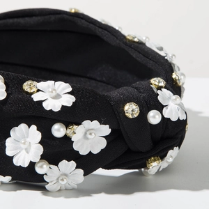 Macro detail of fabric headband featuring white silk flowers, faux pearls and clear rhinestones