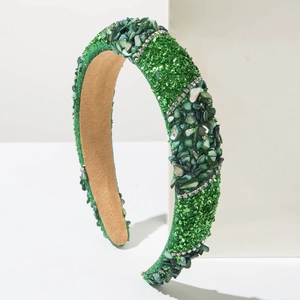 Fashion wide headband with green stones and sparkling diamonds on a white base