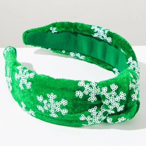 Close-up of green velvet Christmas headband with white sequin snowflake patterns