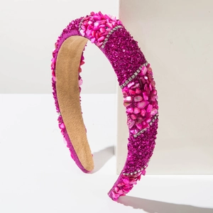 Detail of fuchsia wide headband featuring pink stones, purple glitter, and shiny rhinestones